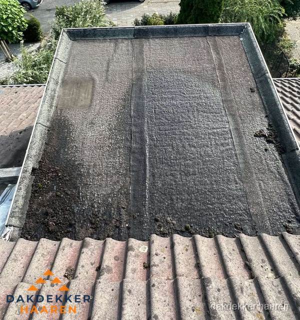 Verouderd plat dak met bitumen en slijtage voor lekkage inspectie in Haaren Verouderd plat dak met bitumen en slijtage voor lekkage inspectie in Haaren