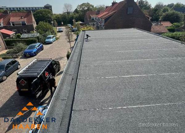 Nieuw bitumen plat dak met uitzicht over woonwijk in Haaren Nieuw bitumen plat dak met uitzicht over woonwijk in Haaren